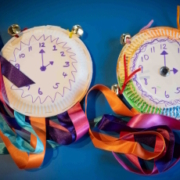 Paper plates with hand-drawn clock faces and colourful ribbons