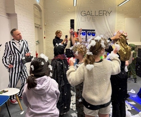 A crowded room of children having fun playing with foam